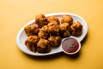 rava Bhajj or bhajiya also known as suji Pakoda or semolina Pakora, served with tomato ketchup. selective focus