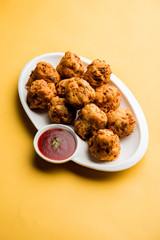 rava Bhajj or bhajiya also known as suji Pakoda or semolina Pakora, served with tomato ketchup. selective focus