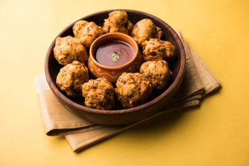 rava Bhajj or bhajiya also known as suji Pakoda or semolina Pakora, served with tomato ketchup. selective focus