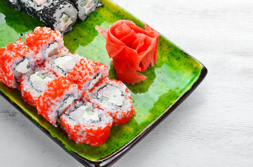 Sushi and maki rolls on a plate. Top view. Free space for your text. On a white background.