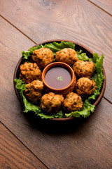 rava Bhajj or bhajiya also known as suji Pakoda or semolina Pakora, served with tomato ketchup. selective focus