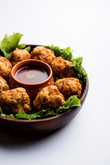 rava Bhajj or bhajiya also known as suji Pakoda or semolina Pakora, served with tomato ketchup. selective focus