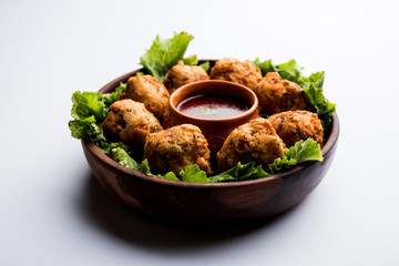 rava Bhajj or bhajiya also known as suji Pakoda or semolina Pakora, served with tomato ketchup. selective focus