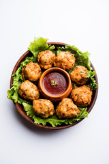 rava Bhajj or bhajiya also known as suji Pakoda or semolina Pakora, served with tomato ketchup. selective focus