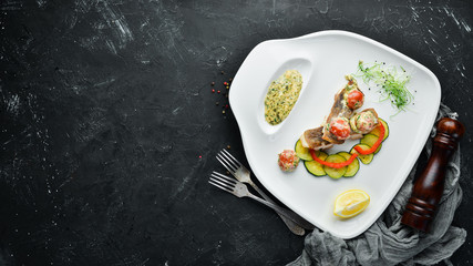 Baked fish fillet with vegetables. Top view. Free space for your text.