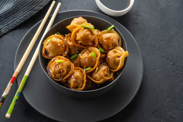 Asian dumplings in bowl, chopsticks, plates. Asian table setting. Chinese dumplings for dinner. Selective focus. Asian style decoration. Chinese fresh homemade food. Closeup