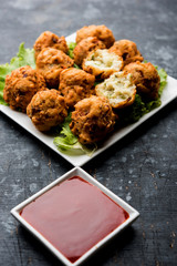 rava Bhajj or bhajiya also known as suji Pakoda or semolina Pakora, served with tomato ketchup. selective focus
