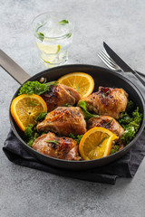 Chicken thighs with orange is a pan.