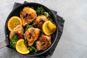 Chicken thighs with orange is a pan.