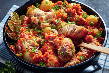 close-up of braised hake in a black pan