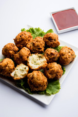 rava Bhajj or bhajiya also known as suji Pakoda or semolina Pakora, served with tomato ketchup. selective focus