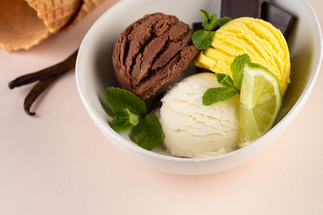 Trio of tasty chocolate vanilla and lime flavored frozen dessert in a white bowl.