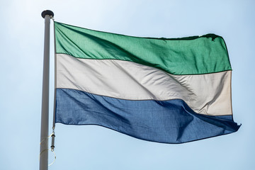 Sierra Leone flag waving against clear blue sky
