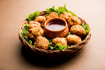 rava Bhajj or bhajiya also known as suji Pakoda or semolina Pakora, served with tomato ketchup. selective focus