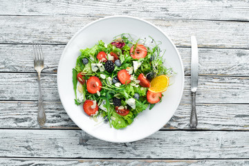Salad. Salad of arugula, blue cheese, strawberries and blueberries. Top view.