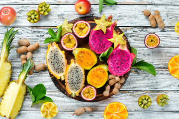 Tropical fruits - Maracuya, pineapple, dragon fruit, kiwi and cactus on a white background. Top view. Free space for text.