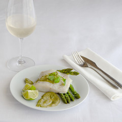Baked fillet fish  with garnish and  sauce in the restaurant table .