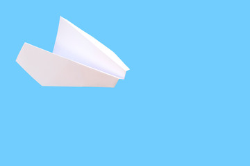 White paper plane on a blue background. Travel concept mockup