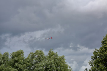 A large civil aviation aircraft flies in the sky in cloudy weather