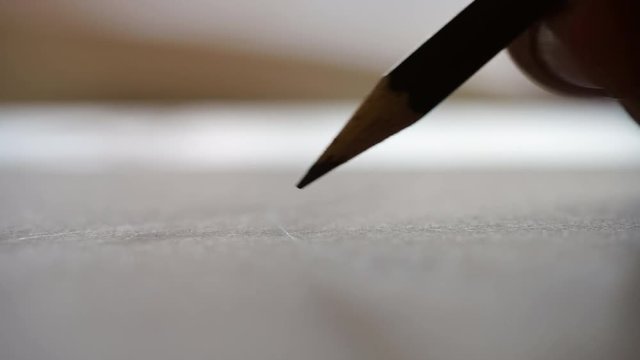 Artists hands drawing wooden pencil on paper. Close-up 4K