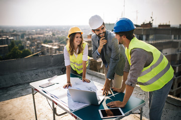 Group of engineers, architects, business partners at construction site working together
