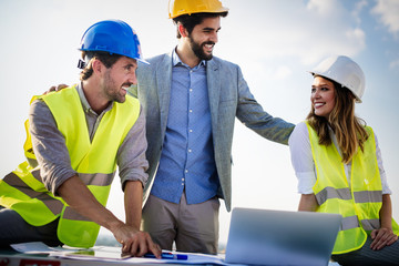 Group of engineers, architects, business partners at construction site working together