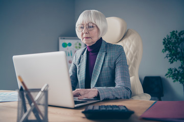 Photo of aged business lady head big organization writing report sitting modern chair notebook table wear specs plaid costume jacket