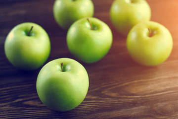 Group of green apples on brown wooden background. Close up