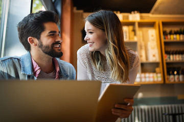 Smiling friends using notebook in cafe at the university