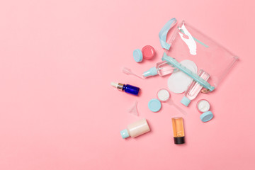 Set of travel size cosmetic bottles on pink background. Flat lay of cream jars. Top view of bodycare style concept