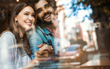 Happy couple hugging at bar and having date