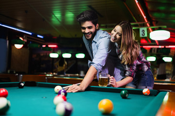 Couple drinking beer and playing snooker on date