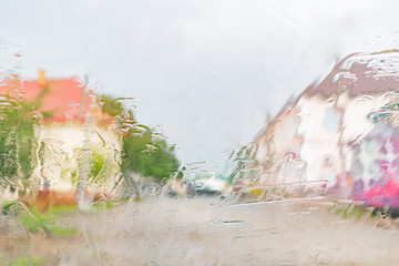 Street view through the wet glass of the car