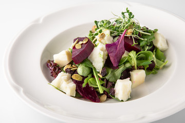 Nutritious, healthy, vitamin, dietary salad of boiled beets, cheese, arugula and nuts. Banquet festive dishes. Gourmet restaurant menu. White background.
