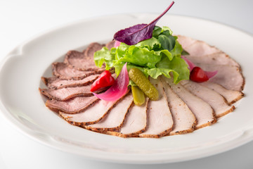 Slicing gourmet meat, pastrami, podcherevka, bastrum, beef and pork. Banquet festive dishes. Gourmet restaurant menu. White background.