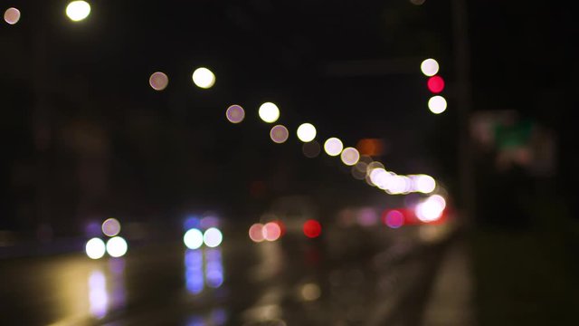 Blurry traffic lights shot on a city boulevard in the late hours of the night.