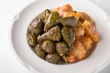 Dolma, rolls of cabbage and grape leaves with rice and meat. Banquet festive dishes. Gourmet restaurant menu. White background.