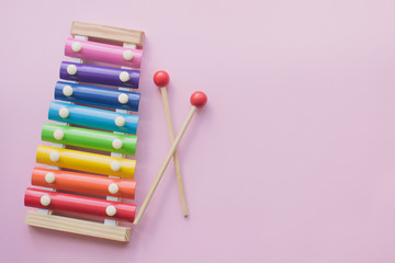 Rainbow Colored Wooden Toy Xylophone on pink bacground. toy glockenspiel made of metal and wood. Copyspace