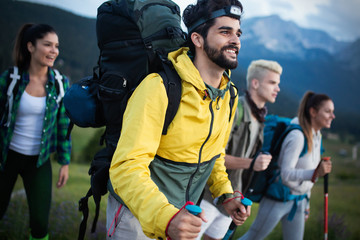 travel, tourism, hike, gesture and people concept - group of smiling friends with backpacks