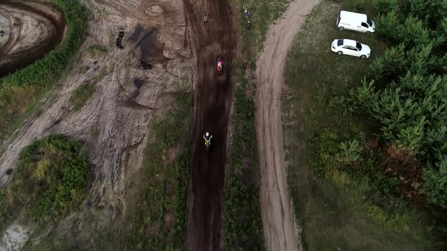 Offroad motorcycling. Two race drivers cross the finishing line. Aerial shot of dirty track