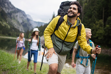 Smiling friends walking with backpacks. Adventure, travel, tourism, hike and people concept.
