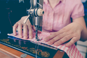 woman seamstress using retro sewing machine