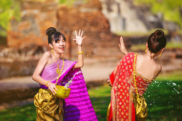 thai woman in traditional thai dresses enjoy to playing water splash in songkran festival