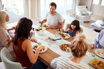 Three generation white family sitting at the dinner table for a family meal, elevated view