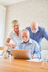 Pflegekraft betreut Senioren im Computerkurs