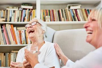 Fotobehang Altenpflegerin und Senior Frau lachen zusammen © Robert Kneschke