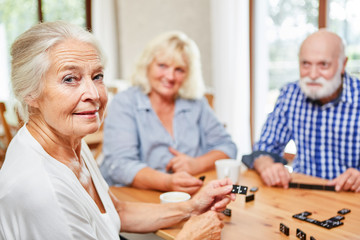 Ehrgeizige Seniorin spielt mit Freunden Domino