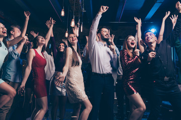 Portrait of charming funny funky youth fellows formalwear frmal wear rasise hand sarms scream shout loud place discotheque