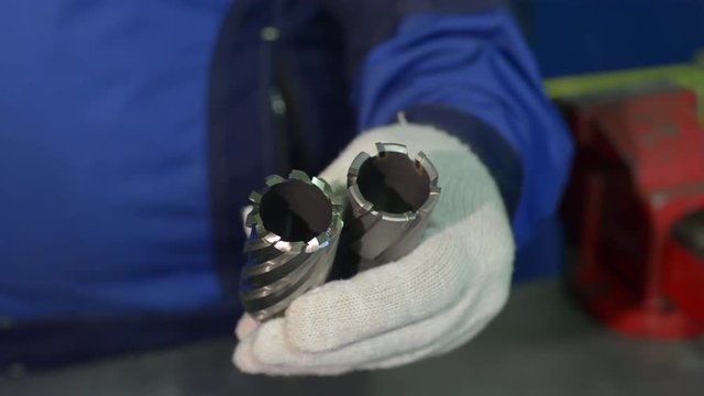 A man in seals holds a crown bit with tungsten carbide tines and a HSS crown bit in his hands