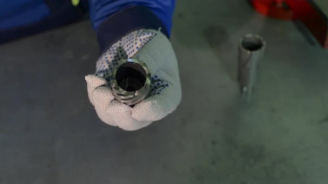 A man in gloves holds HSS crown bit in his hands
